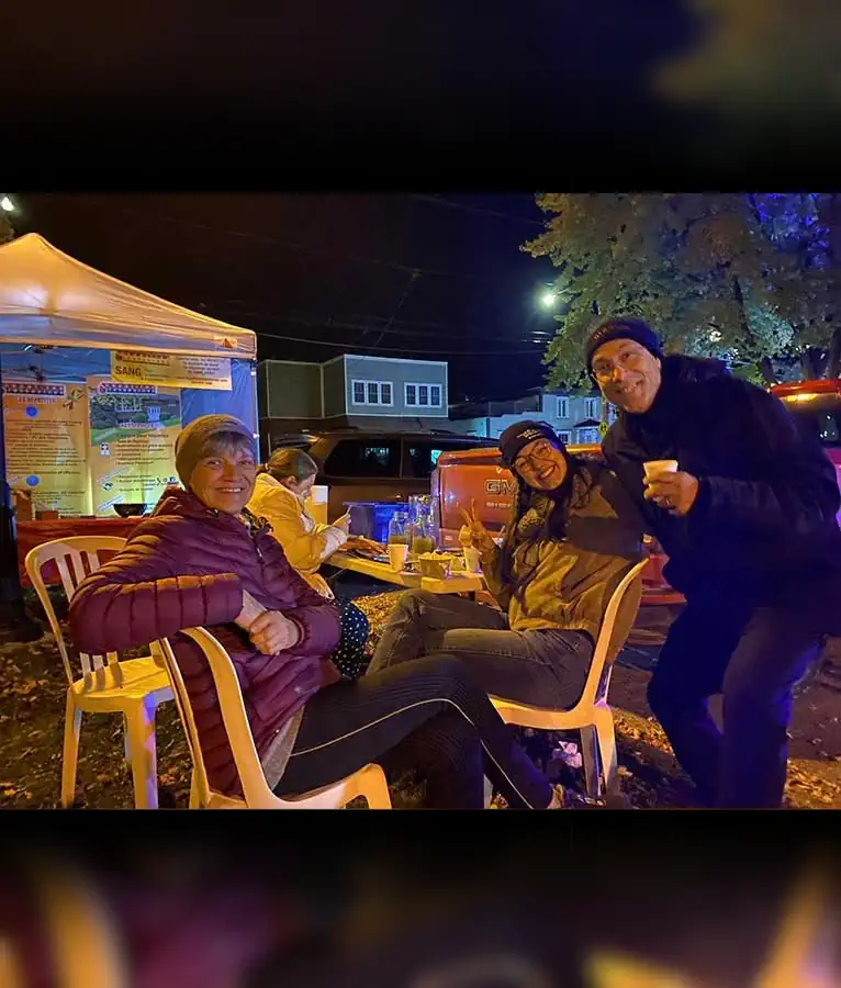 Des personnes assises à une table sourient à la caméra