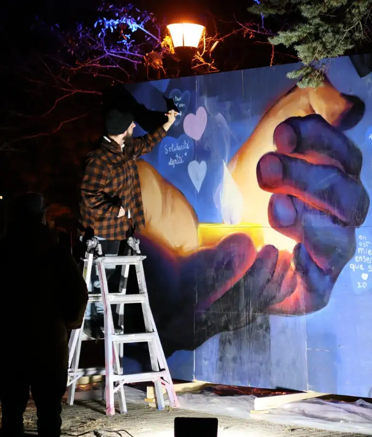 Un artiste peintre produit une murale significative à la main à l'occasion de la Nuit des sans-abris 2026 à Bécancour.