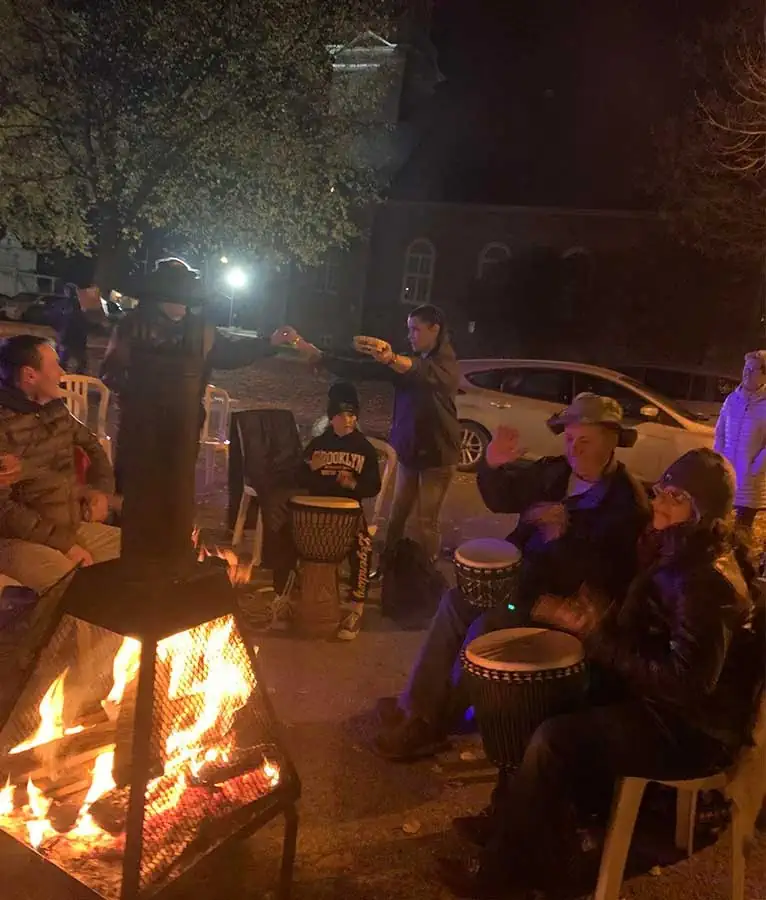 Des gens sont assis ensemble autour d'un feu